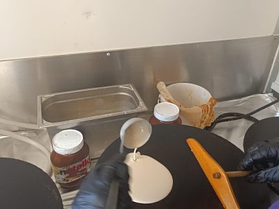 déposer de la pâte à crêpe sur une billig, la traditionnelle crêpière bretonne